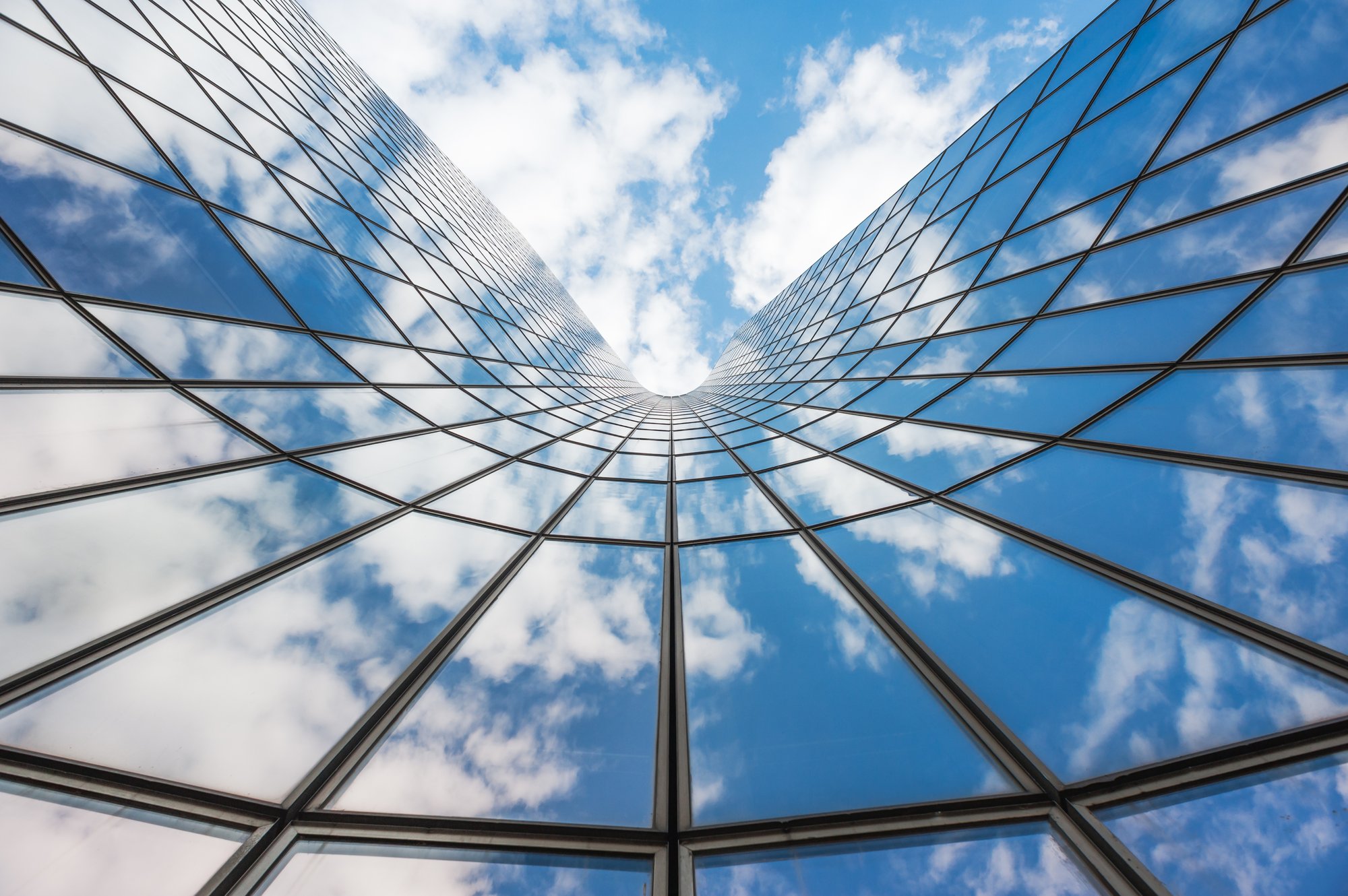 Header_Blue sky white clouds reflecting in glass building modern architecture 20250221 GLO EN